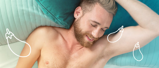 shirtless man in bed with one arm over his head.