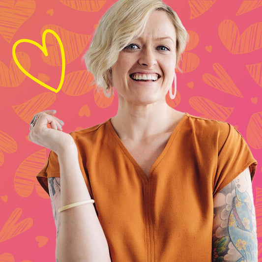 Anne Hodder-Shipp author of The 18 Modern Love Languages, smiling, against pink and orange background