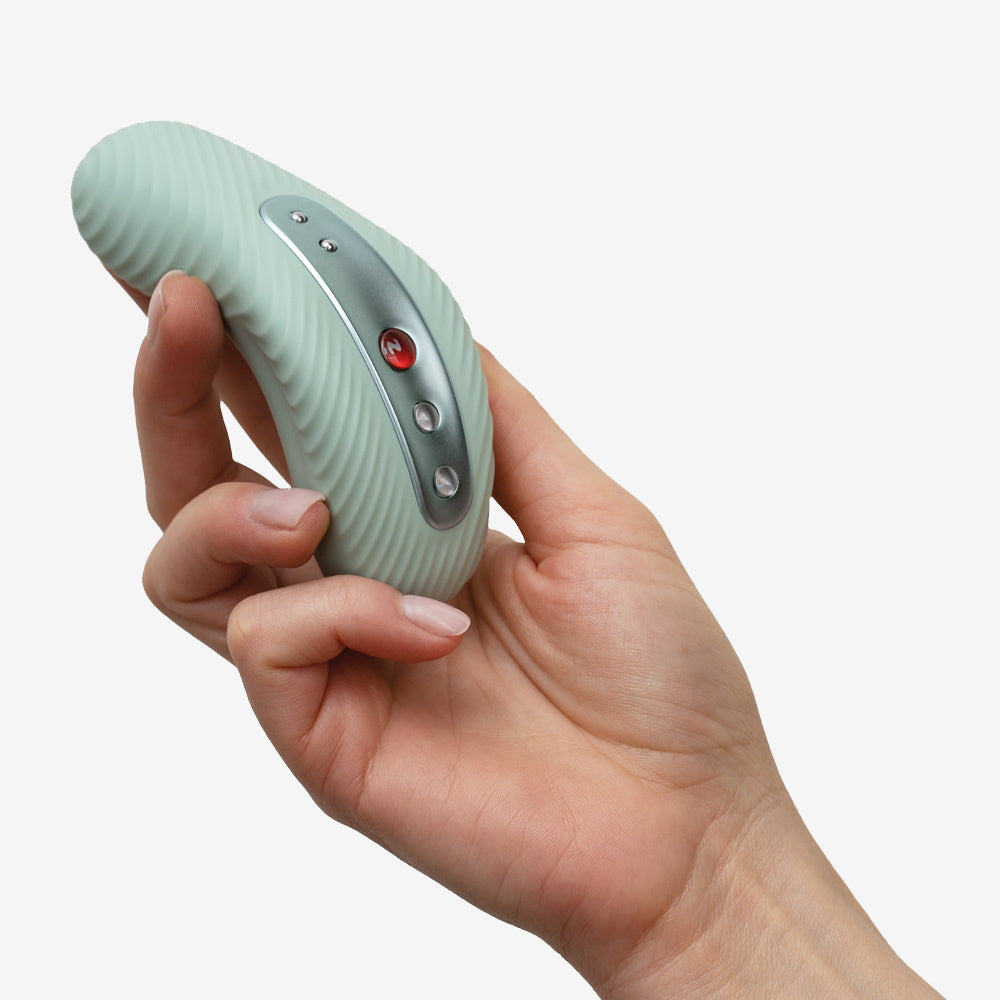 Laya 3 Lay-On Vibrator in sage held in a hand