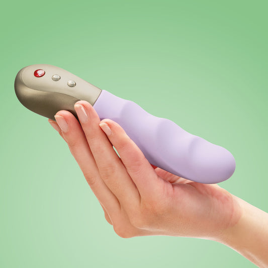 Stronic Petite by Fun Factory in lilac, held in a hand on a green background