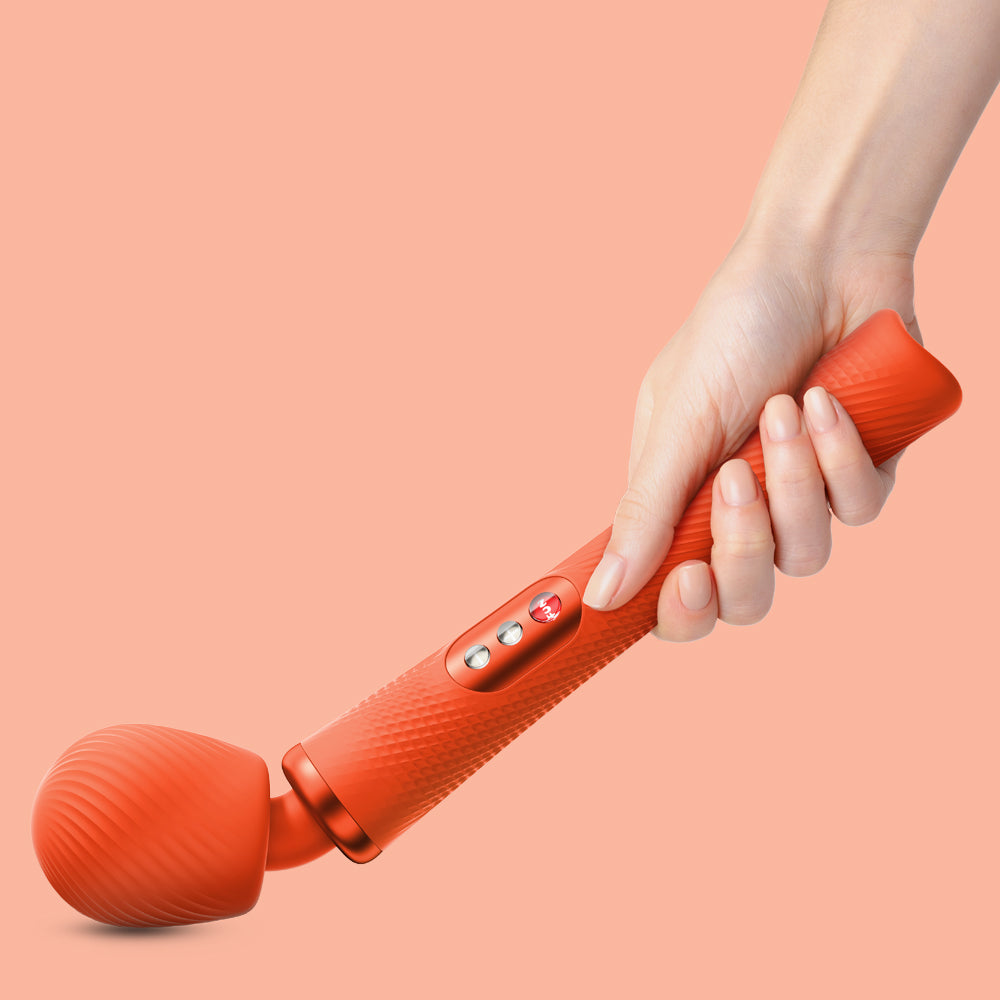 Wand Vibratory by Fun Factory in orange held in hand on an orange background
